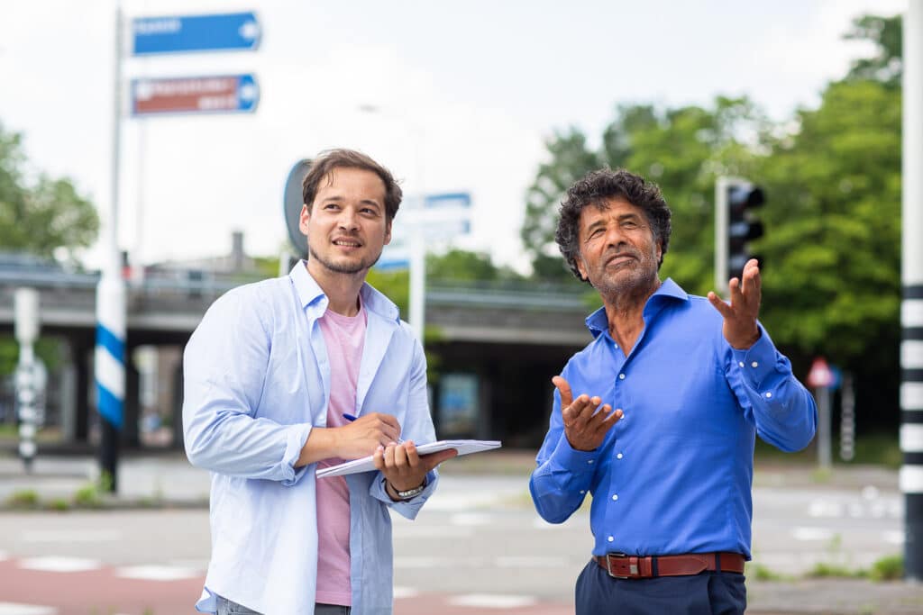 Twee mannen overleggen op straat en maken aantekeningen