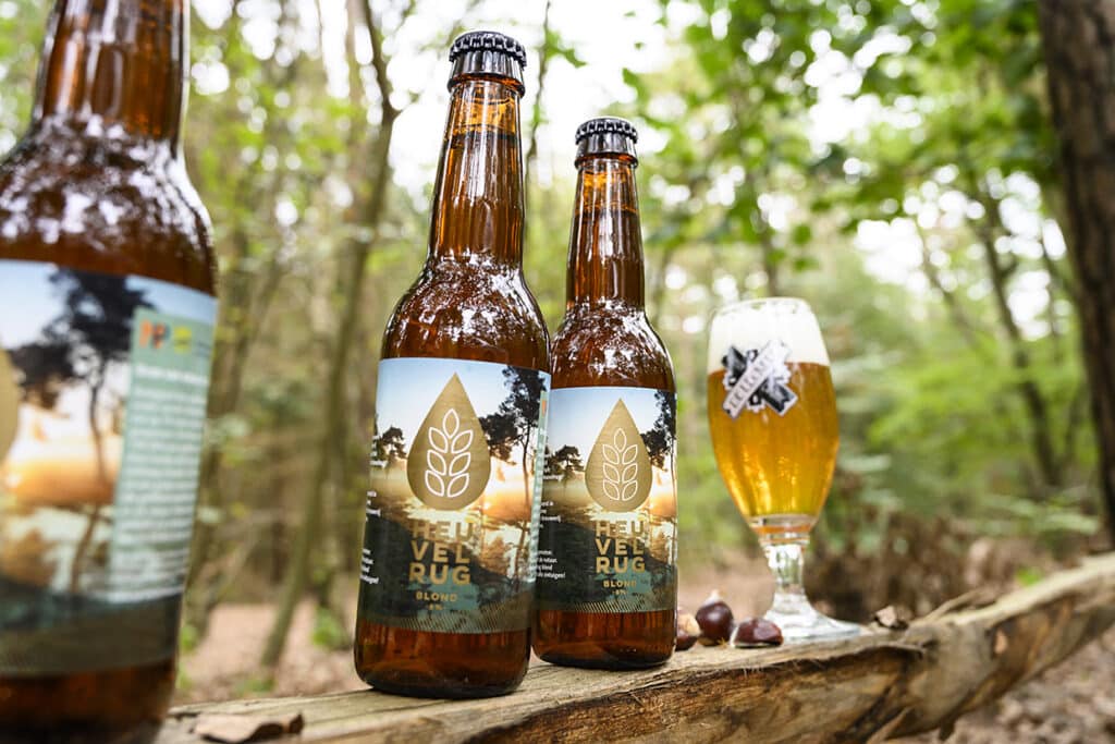 Drie flesjes en een glas bier van De Leckere in het bos