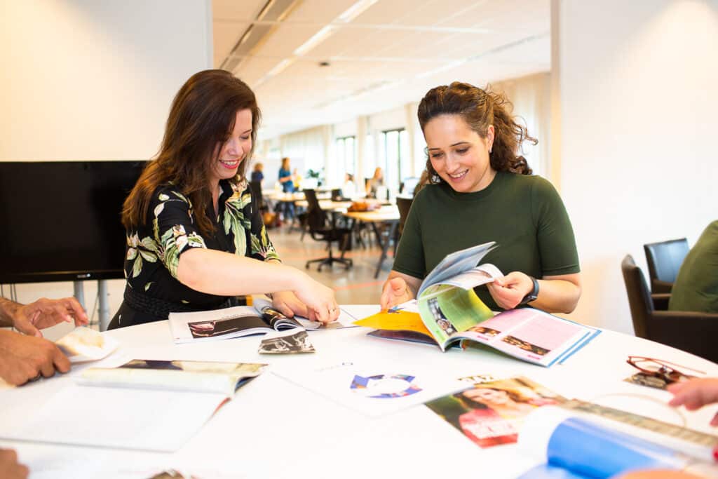 Collega's zoeken afbeeldingen in tijdschriften voor moodboard