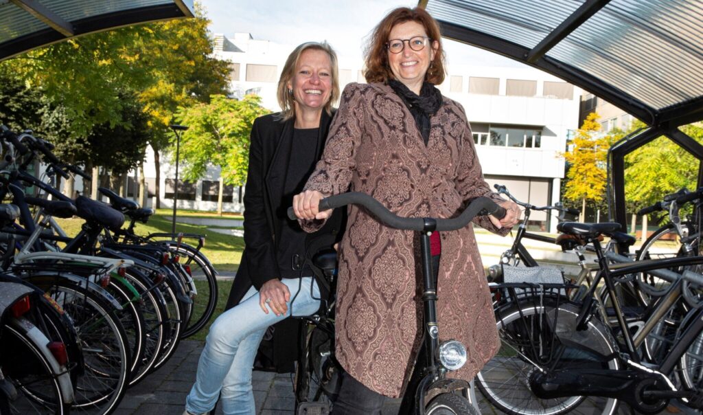 Melanie Kuster en Tanja Steenhorst op de fiets in de fietsenstalling bij hogeschool Fontys