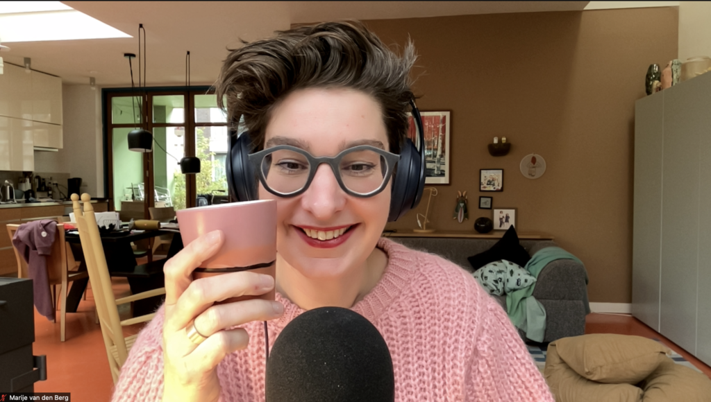 Marije van den Berg met kopje koffie achter de podcastmicrofoon