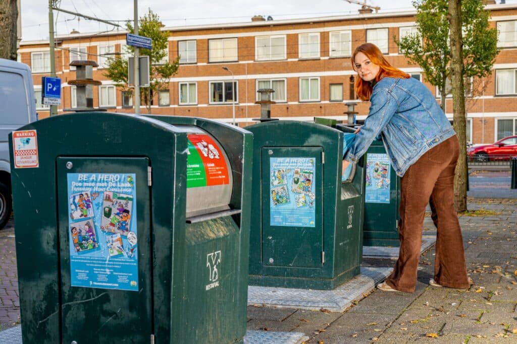 Containeradoptant in Den Haag gooit afval in een afvalcontainer