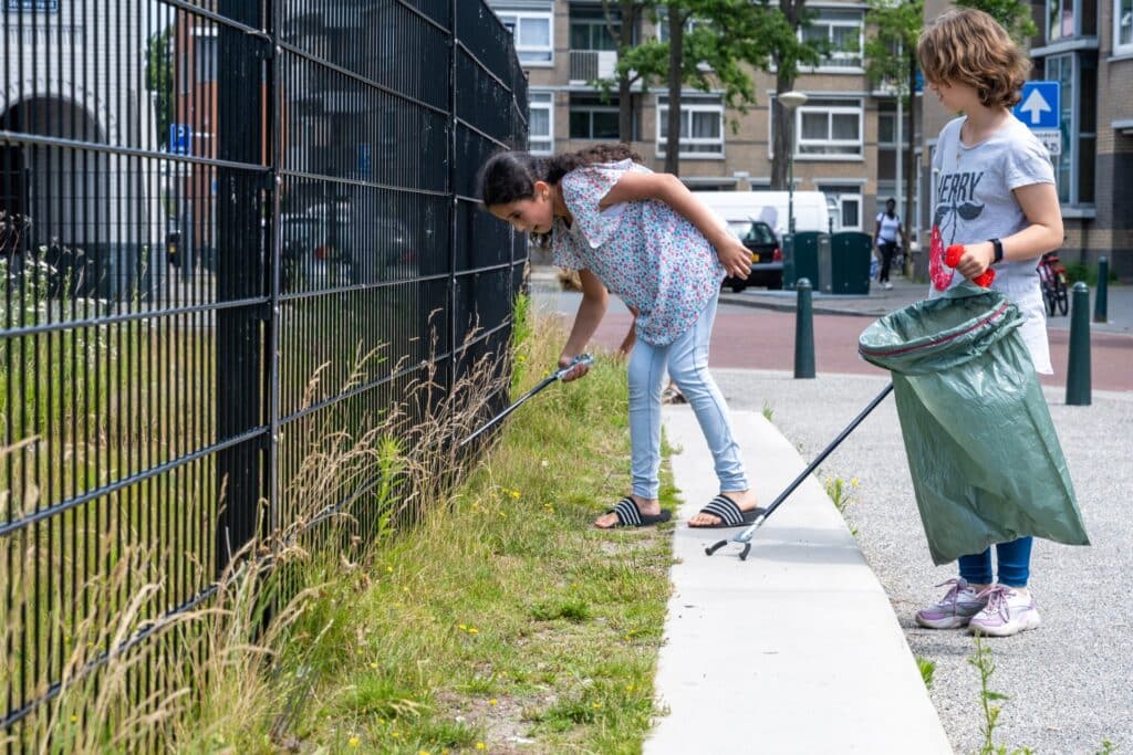 Kinderen rapen afval in Den Haag met afvalknijper