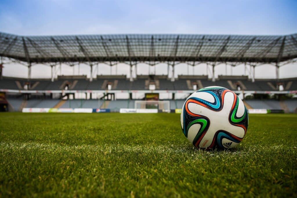 Een voetbal ligt op een voetbalveld in een stadion.