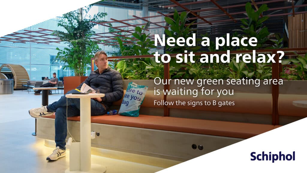 Reclamebord op Schiphol met informatie waar reizigers rustig kunnen werken. Op de foto zit een meneer/reiziger op een bankje naast een plantenbak.